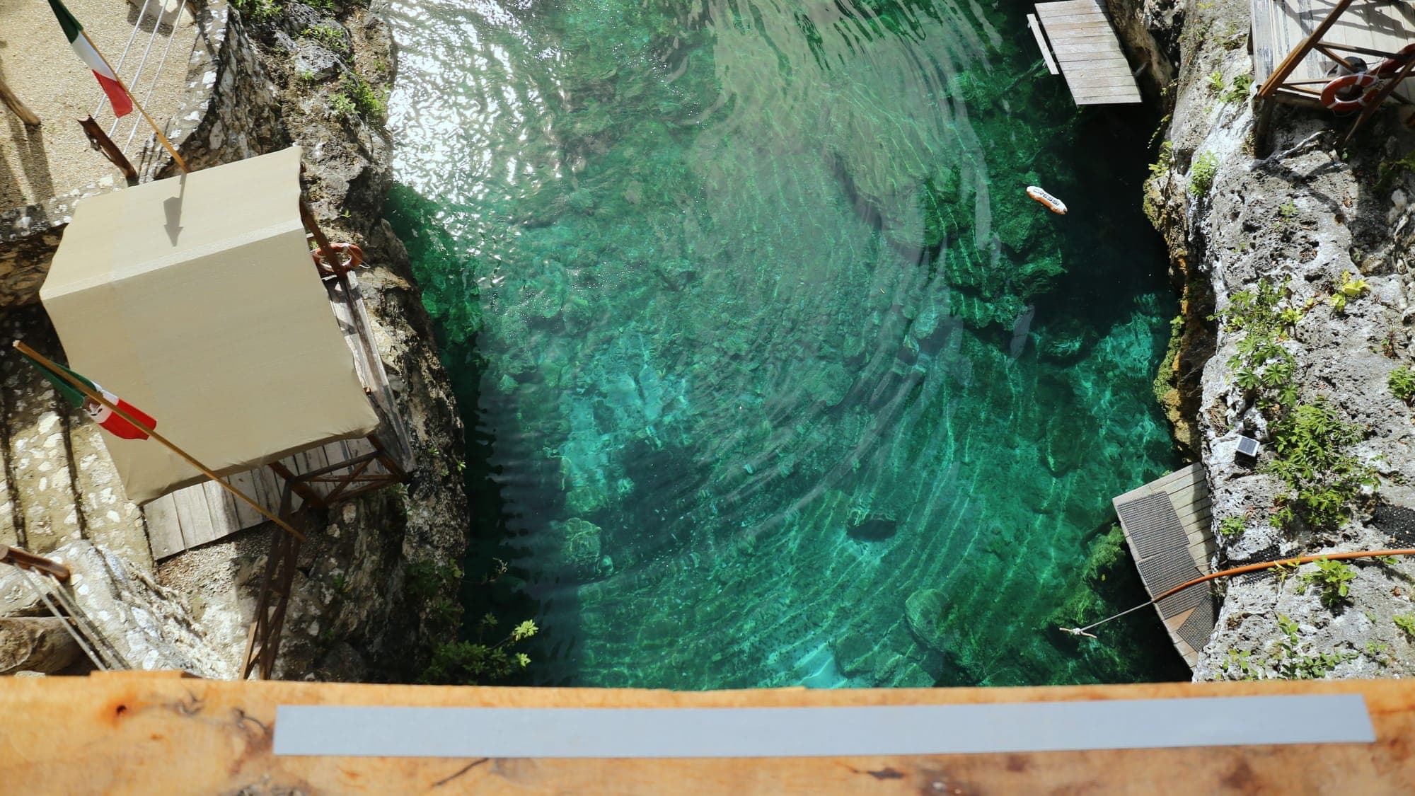 The view straight down from the edge of the jumping platform to the turquoise water