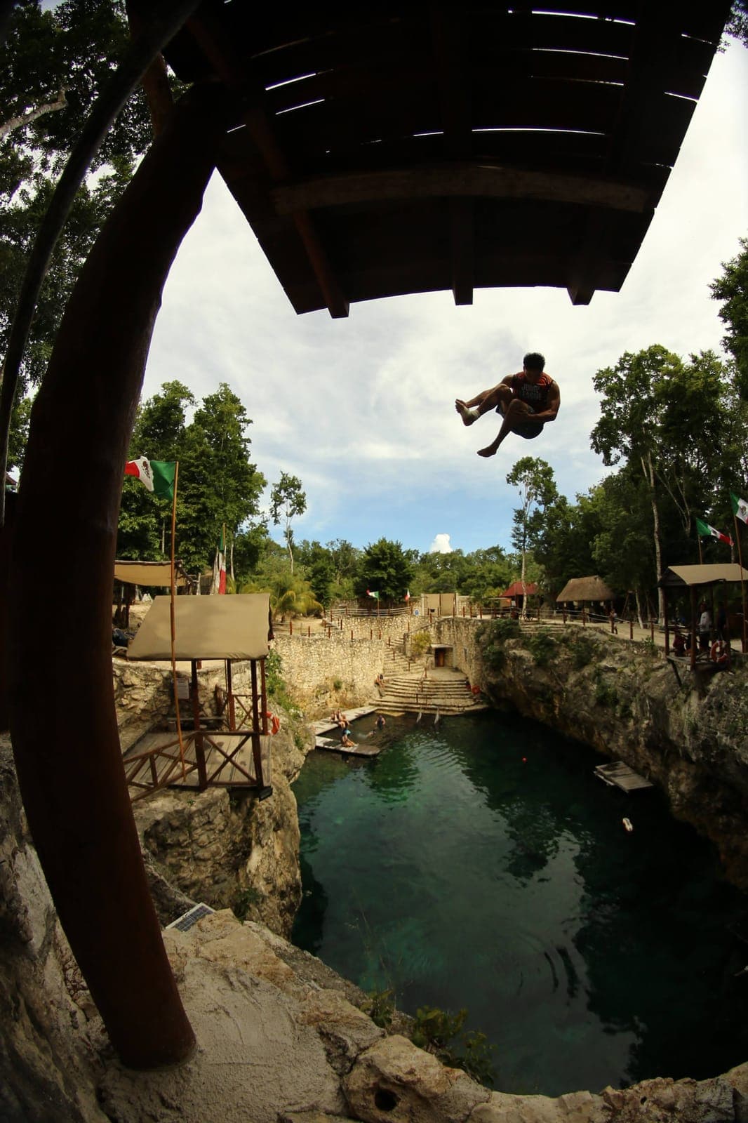 A jumper leaping out from the tower toward the cenote