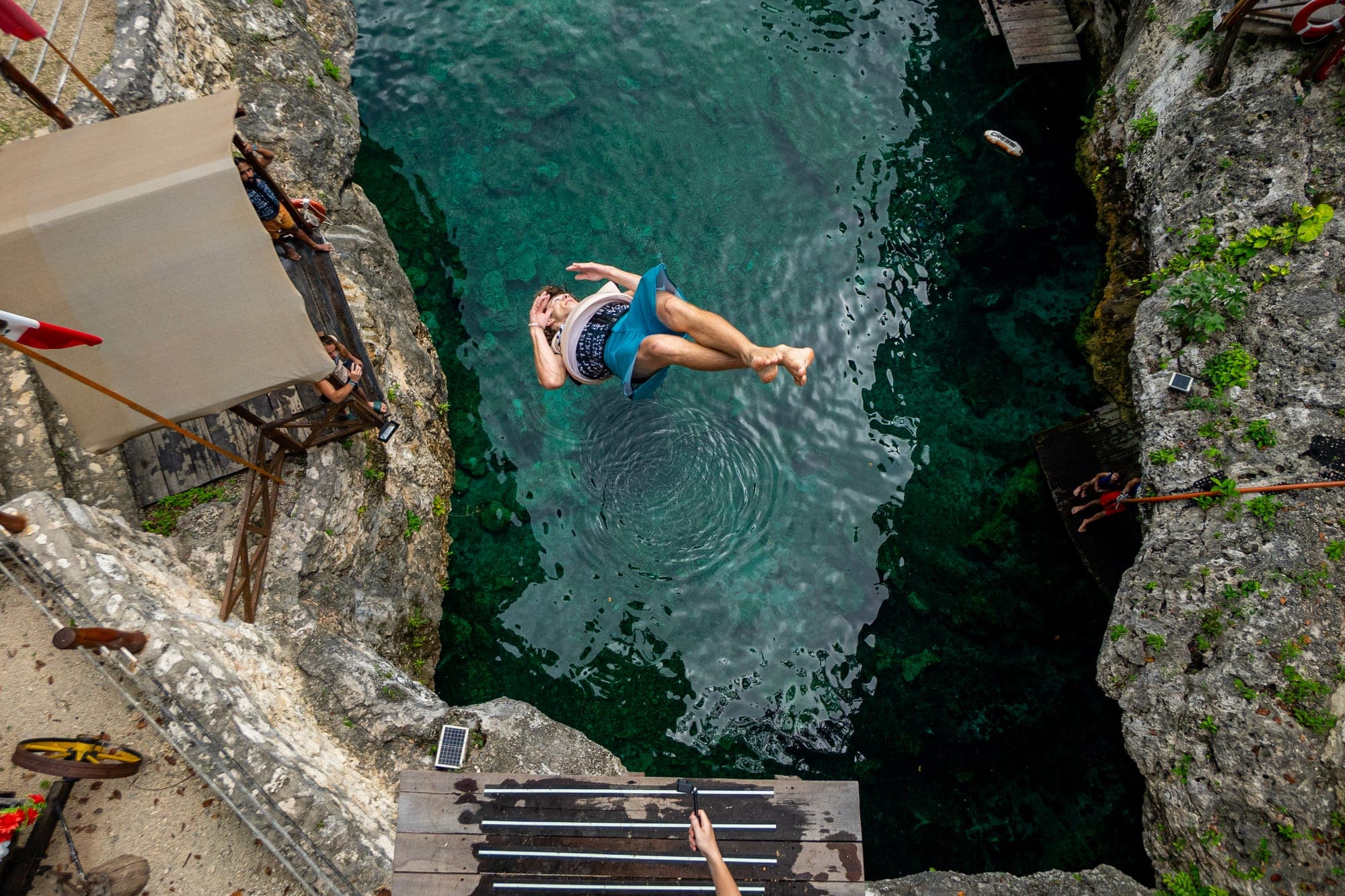 Looking straight down at a jumper diving into a cenote